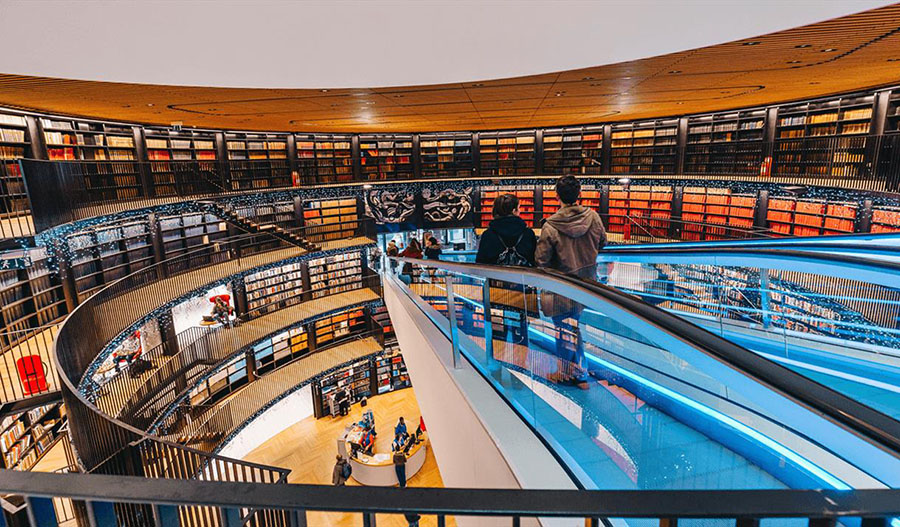 Young couple on the escalator inside the book rotunda at Library of Birmingham